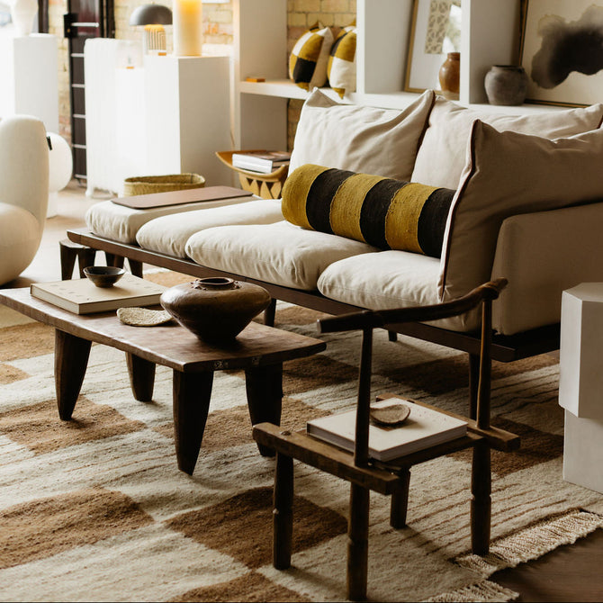 Modern living room with a sofa, coffee table, and decorative items.