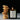 Candle labeled 'Flamingo Estate' with a stack of cookies on a reflective surface.