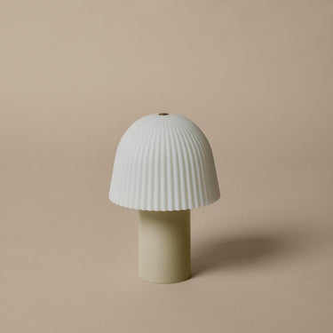 Mushroom-shaped lamp with ribbed design on a beige background
