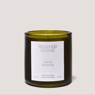Green candle with a white label on a light gray background