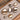 Seven polished metallic pebble-shaped hardware displayed on a light gray velvet-lined jewelry box, with a terrazzo-patterned surface visible in the background.