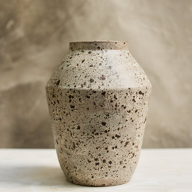 Speckled ceramic vase on a neutral background