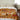 Bed with a patterned quilt featuring animals in a bedroom setting.