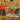 Patterned fabric with red, black, and yellow design on a mustard background