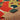 Close-up of a colorful woven fabric with a brand tag, featuring red, yellow, and black patterns.