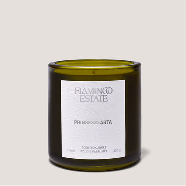 Green candle with a white label on a light gray background