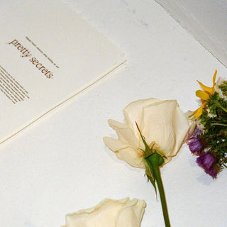 Pretty Secrets Promo Image With Flower and Invitation Card