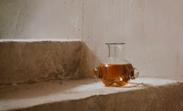 Glass carafe with liquid on a stone surface