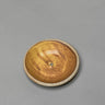Round ceramic object with a textured surface on a gray background