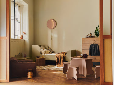 Modern bedroom with a bed, desk, and armchair.