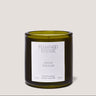Green candle with a white label on a light gray background