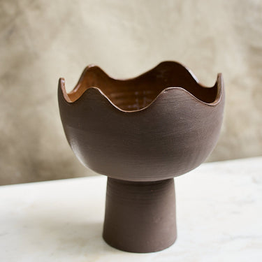 Ceramic bowl with wavy edge on a neutral background