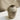 Speckled gray ceramic vase on a marble surface with a neutral background