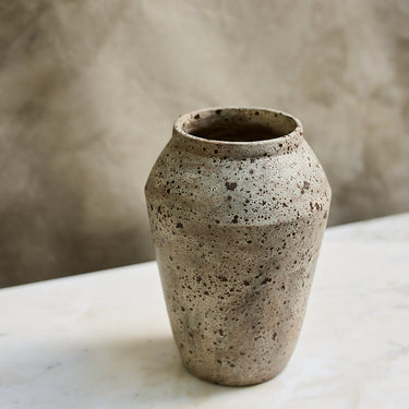 Stoneware vase on a marble surface with a neutral background