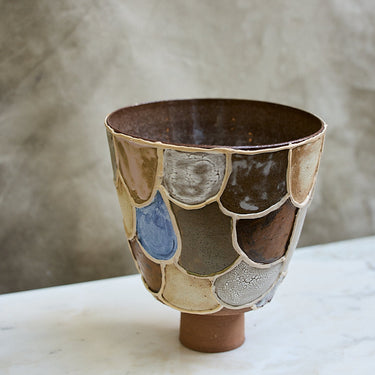 Ceramic cup with multicolored glaze on a marble surface