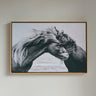 Framed artwork of two horses embracing on a plain wall.
