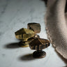 Three brass cabinet knobs on a marble surface with a cloth.