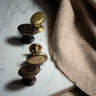 Set of vintage-style cabinet knobs on a marble surface with fabric in the background