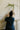 Person arranging flowers in a vase against a white wall.